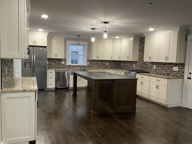 kitchen with appliances with stainless steel finishes, white cabinetry, dark wood-type flooring, and decorative light fixtures