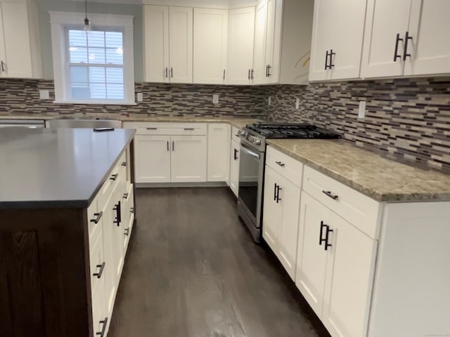 kitchen with white cabinets, stainless steel gas range, dark wood-type flooring, and tasteful backsplash