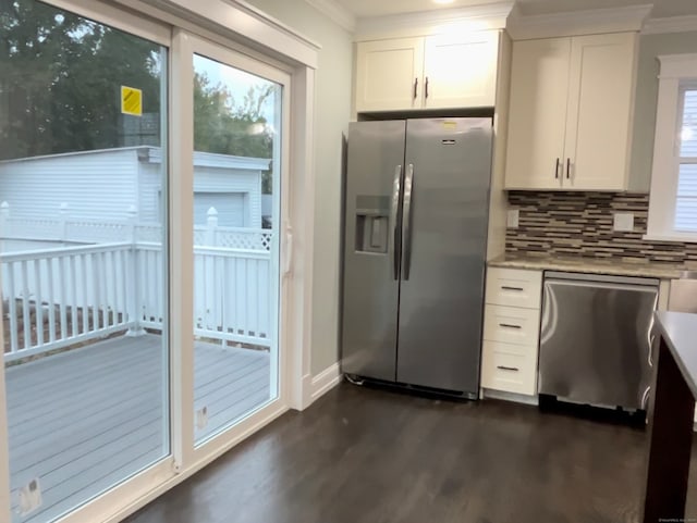 kitchen with appliances with stainless steel finishes, dark hardwood / wood-style floors, ornamental molding, and white cabinetry