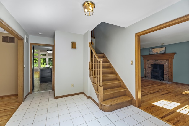 stairs featuring a wood stove, hardwood / wood-style floors, and sink