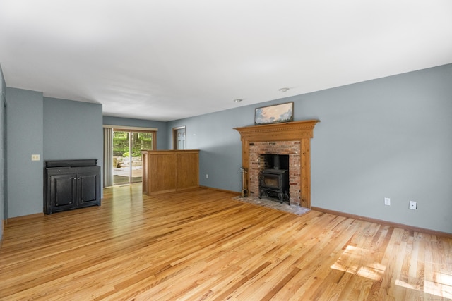 unfurnished living room featuring a wood stove and light hardwood / wood-style flooring