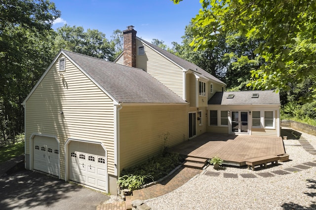 back of property featuring a wooden deck and a garage