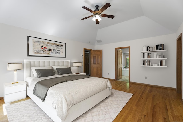 bedroom with hardwood / wood-style flooring, ensuite bath, ceiling fan, and lofted ceiling