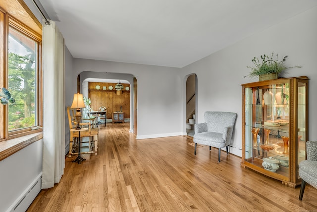 sitting room with a baseboard radiator, light hardwood / wood-style flooring, and plenty of natural light