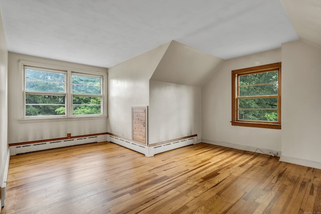 bonus room with light wood-type flooring, vaulted ceiling, and a healthy amount of sunlight