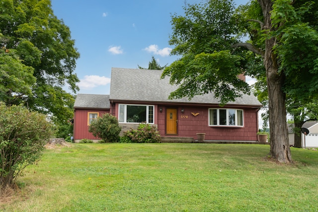 ranch-style house featuring an outdoor structure and a front lawn