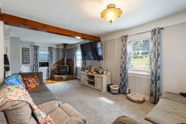 carpeted living room featuring a wood stove, beam ceiling, and a textured ceiling