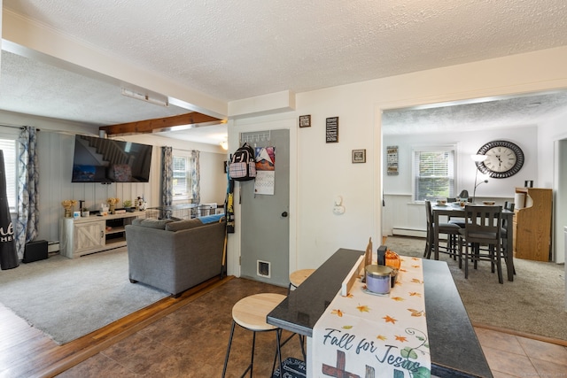 dining space with a textured ceiling, carpet flooring, and a healthy amount of sunlight