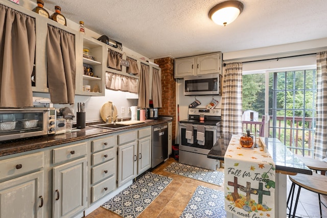 kitchen featuring gray cabinetry, a textured ceiling, and appliances with stainless steel finishes