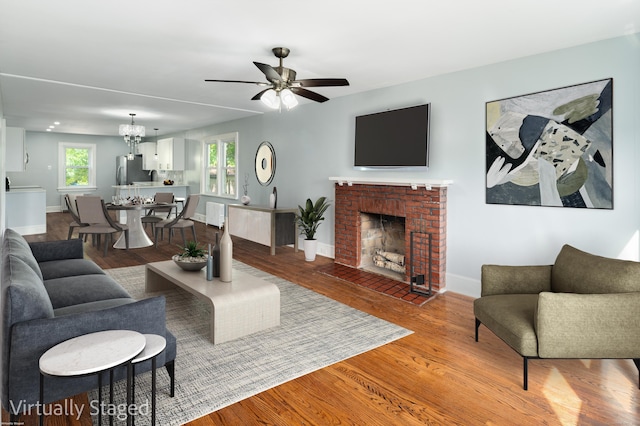 living room featuring a brick fireplace, ceiling fan, and hardwood / wood-style flooring