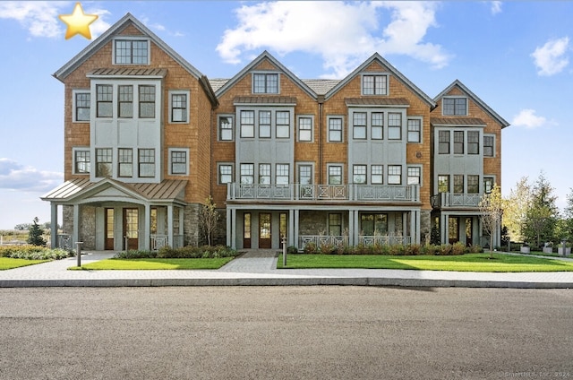 view of front of house with a balcony and a front yard