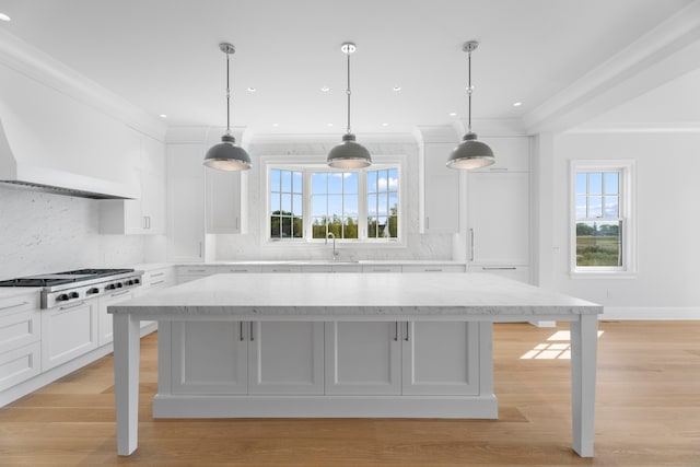 kitchen featuring a breakfast bar, light stone countertops, backsplash, and a wealth of natural light