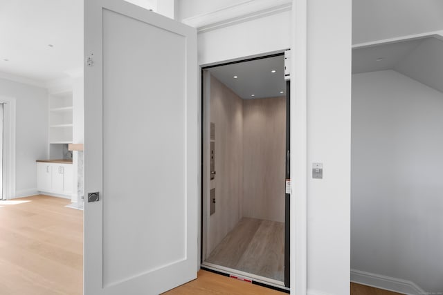 hallway with elevator and hardwood / wood-style flooring