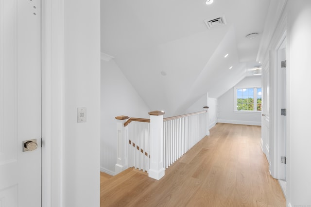 corridor with lofted ceiling and light hardwood / wood-style floors