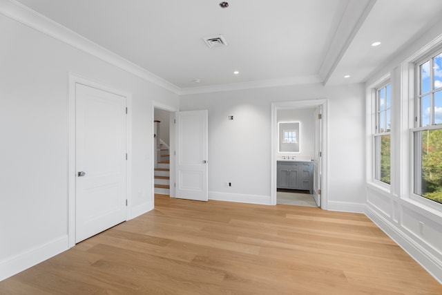 unfurnished bedroom with multiple windows, crown molding, light hardwood / wood-style floors, and ensuite bath