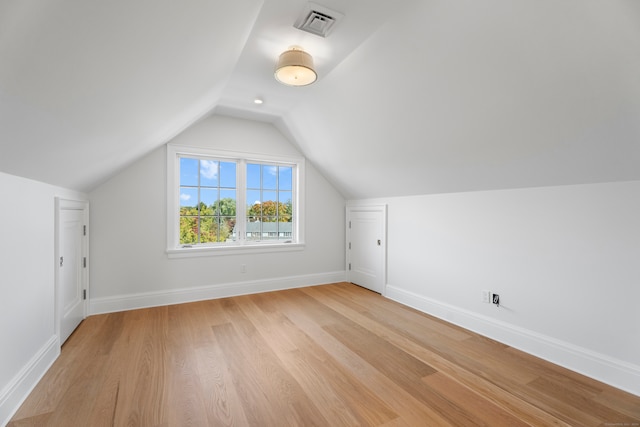 bonus room featuring light wood-type flooring and vaulted ceiling