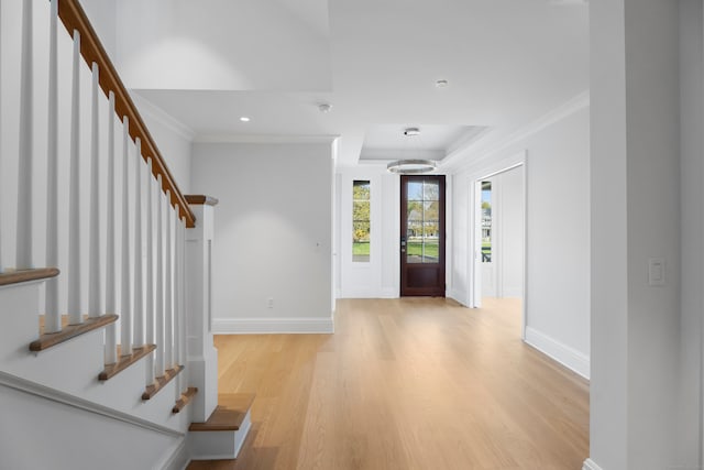 entrance foyer with crown molding and light hardwood / wood-style flooring