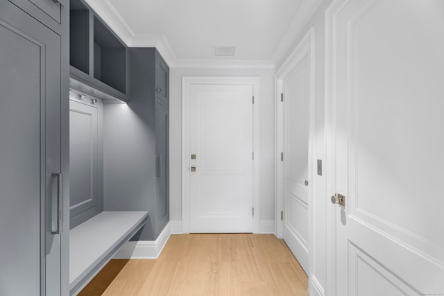 mudroom with ornamental molding and light hardwood / wood-style flooring