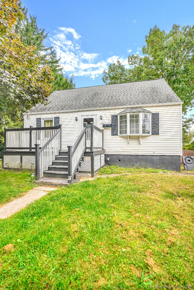 view of front of house with a wooden deck and a front lawn