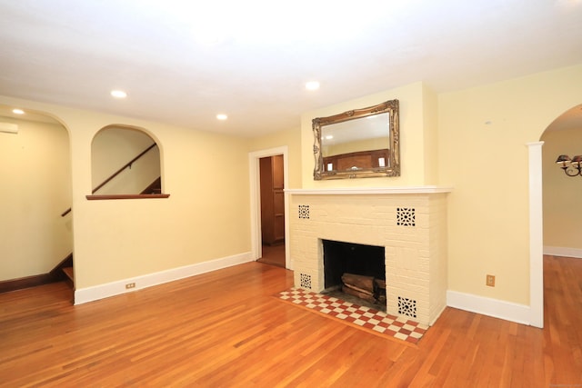 25 Muriel St, Norwalk, CT 06851 - unfurnished living room with wood finished floors, a fireplace, baseboards, recessed lighting, and arched walkways