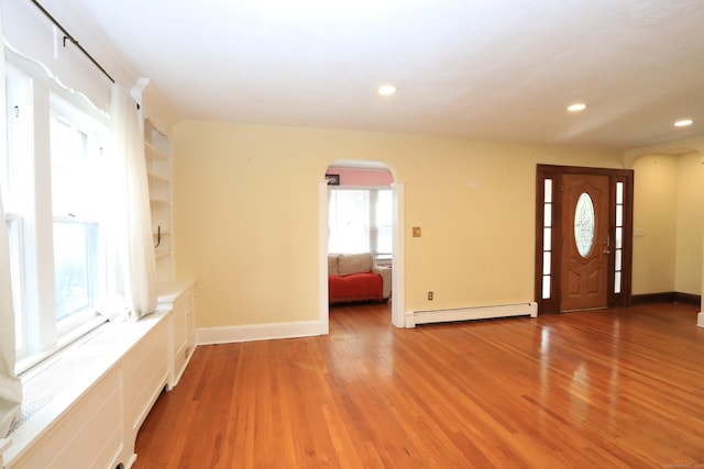 25 Muriel St, Norwalk, CT 06851 - foyer entrance with arched walkways, a baseboard radiator, baseboards, and light wood-style flooring