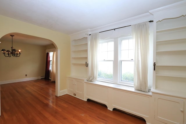 25 Muriel St, Norwalk, CT 06851 - unfurnished room with an inviting chandelier, arched walkways, dark wood finished floors, and a wealth of natural light