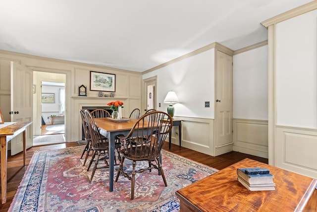 dining area featuring wood-type flooring and crown molding