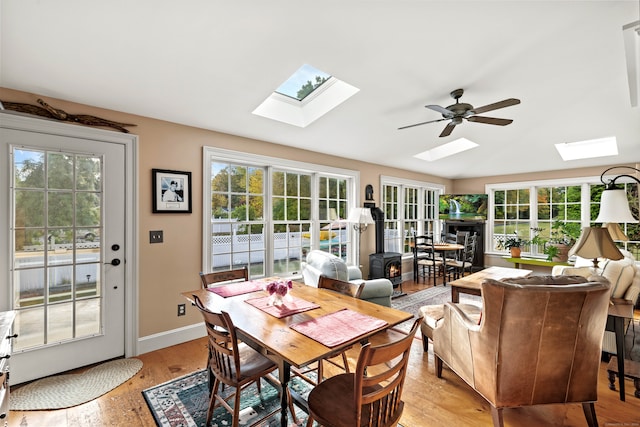 sunroom / solarium with a wood stove, ceiling fan, and plenty of natural light