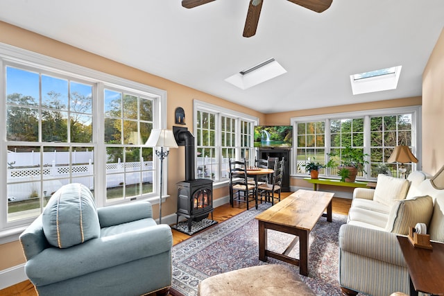 sunroom featuring ceiling fan and a wood stove