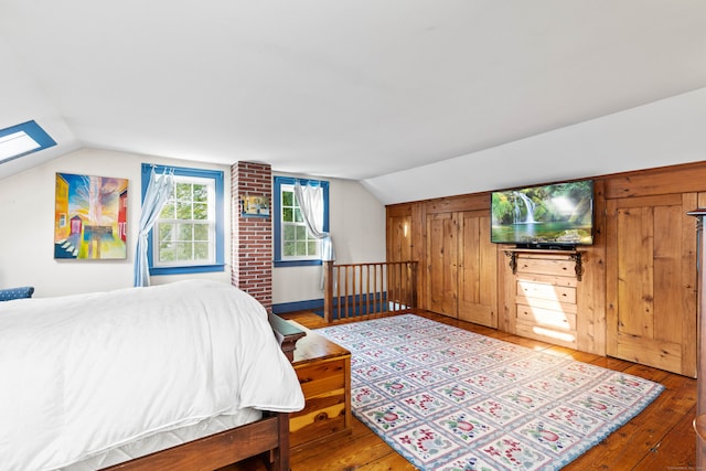 bedroom featuring wood-type flooring and lofted ceiling with skylight