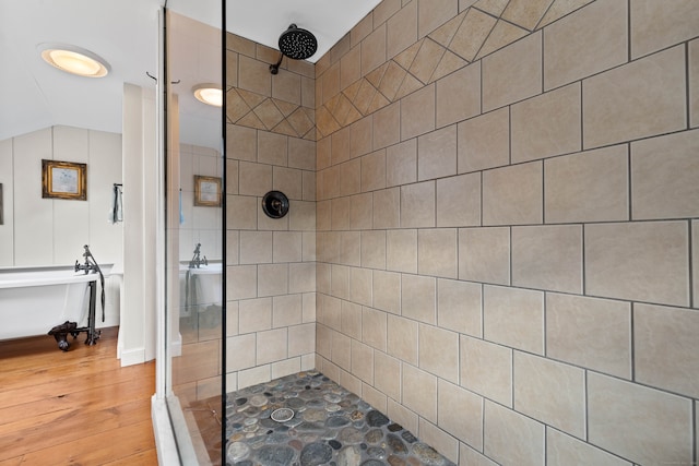 bathroom with wood-type flooring and tiled shower