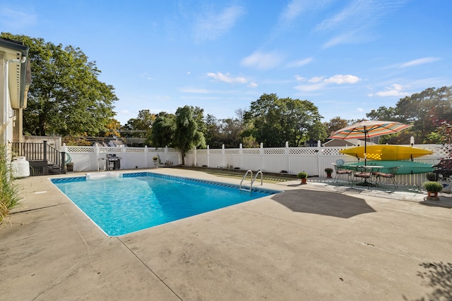 view of swimming pool with grilling area and a patio area