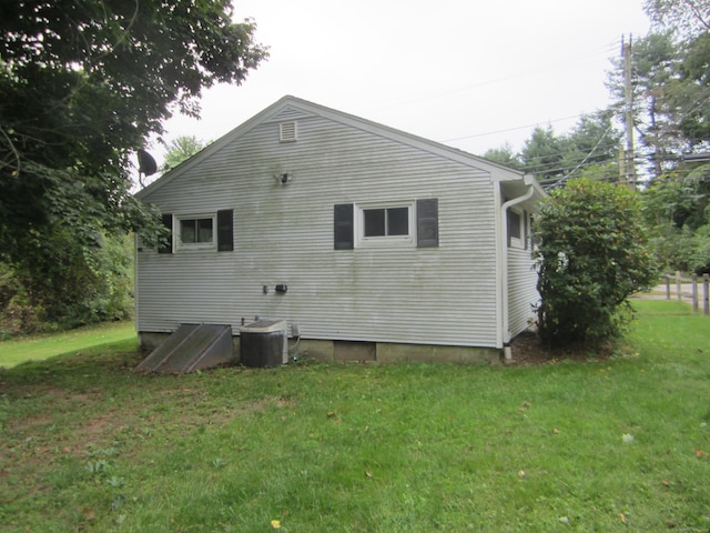 rear view of house with a yard and central air condition unit