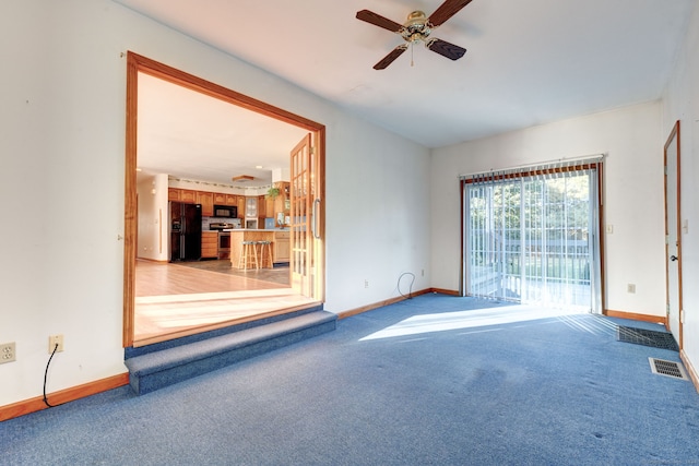 unfurnished living room with light colored carpet and ceiling fan