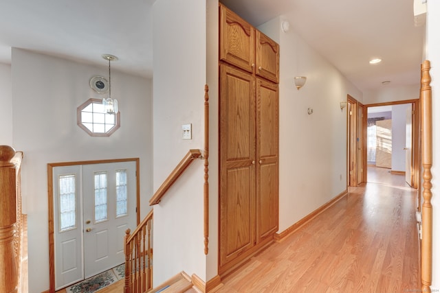 foyer entrance with light hardwood / wood-style flooring and a notable chandelier