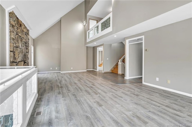 unfurnished living room with light hardwood / wood-style flooring and high vaulted ceiling