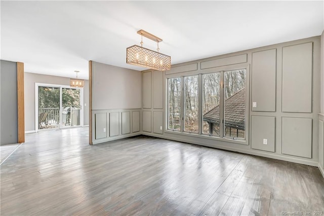 unfurnished room featuring a chandelier and light hardwood / wood-style floors