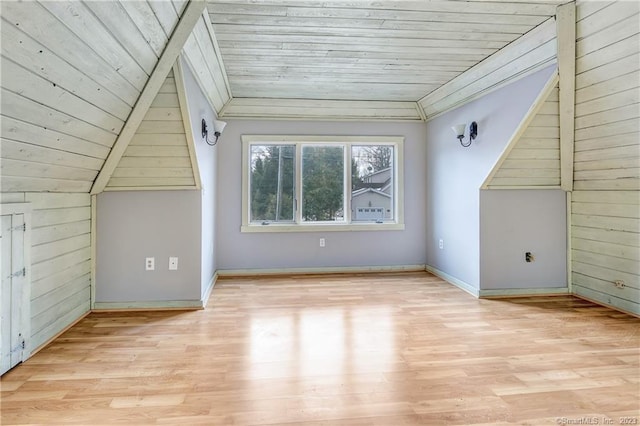 additional living space with wood ceiling, wood walls, and light hardwood / wood-style flooring