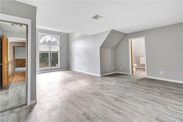 interior space with light wood-type flooring and connected bathroom