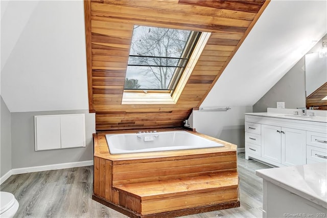 bathroom with vanity, vaulted ceiling with skylight, a bathing tub, and wood ceiling