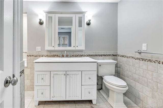 bathroom featuring vanity, tile walls, tile patterned flooring, and toilet