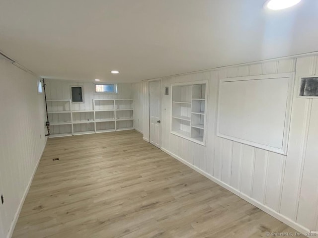 spare room with light wood-style floors and built in shelves