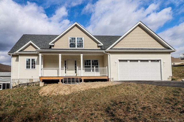 view of front of property with a front yard, a garage, and a porch