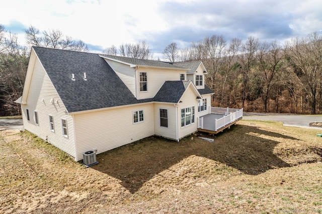 view of side of home with central AC unit and a deck