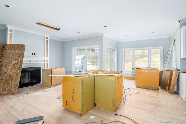 kitchen with light wood-type flooring, crown molding, and a center island