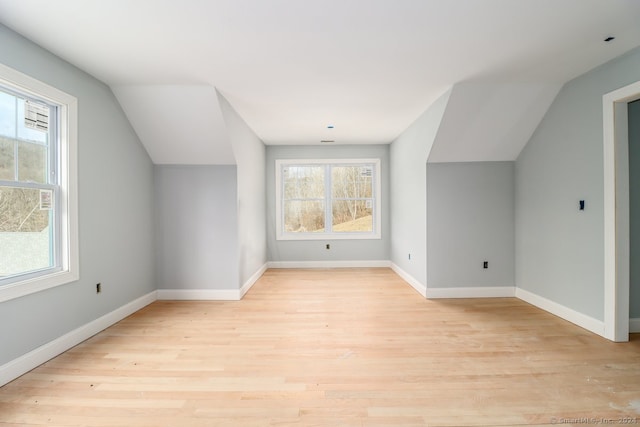 additional living space featuring light wood-type flooring and lofted ceiling