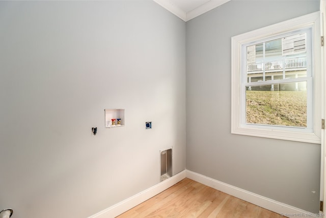 clothes washing area featuring washer hookup, electric dryer hookup, hardwood / wood-style flooring, and ornamental molding