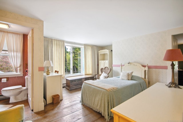 bedroom with light hardwood / wood-style floors and connected bathroom