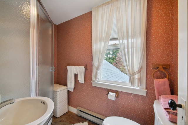 bathroom featuring toilet, wood-type flooring, baseboard heating, sink, and a shower with shower door