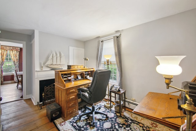 office with hardwood / wood-style floors and a healthy amount of sunlight